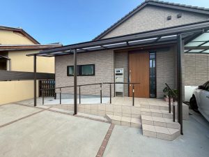 玄関前に車椅子用スロープと手すり・屋根を新設した住宅外観